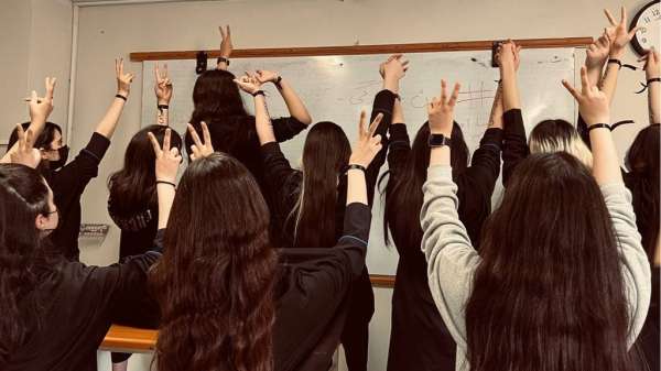 School girls remove their hijabs in protest