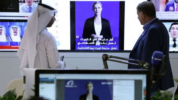 صحفيان يشاهدان فيديو تعريفي لمذيعة الذكاء الاصطناعي فضة على حساب تويتر لمؤسسة كويت نيوز الإعلامية، في مدينة الكويت، 9 أبريل/نيسان 2023