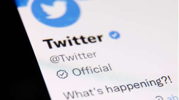 Phone with Twitter logo, new official badge and the phrase