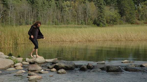 رجل يعبر النهر باستخدام حجارة