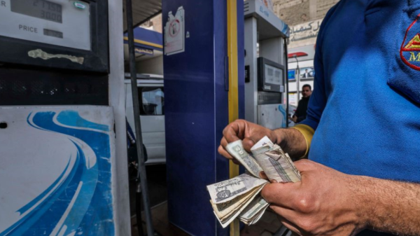 عامل يحسب المال في محطة بنزين في القاهرة في 2 مارس 2023 حيث أعلنت الحكومة المصرية عن زيادة جديدة في أسعار الوقود.