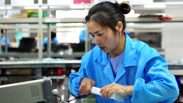 A worker tests lithium battery products for power connection on the production line