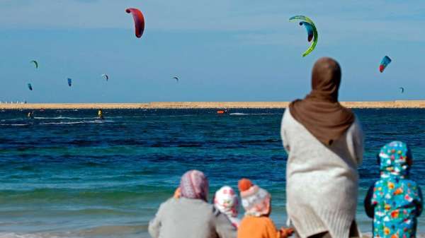 يوم الجمعة، عائلات تشاهد طائرات ورقية قبالة ساحل العاصمة الليبية طرابلس.