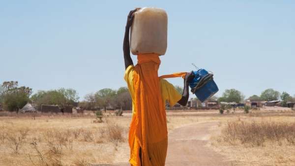 سودانية تحمل وعاء ماء