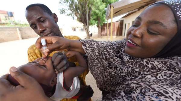 رجل وامرأة يمنحان تطعيما لطفل