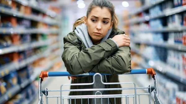 A woman with an empty supermarket trolley