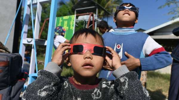 أطفال في ميانمار يرتدون نظارات خاصة لمشاهدة كسوف الشمس