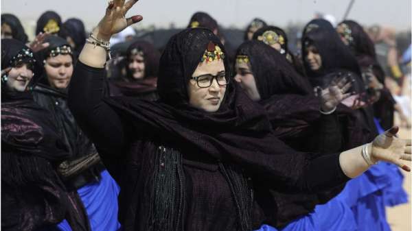 نساء صحراويات يرتدين الحجاب الأسود مع ما يبدو أنه أغلفة زرقاء.