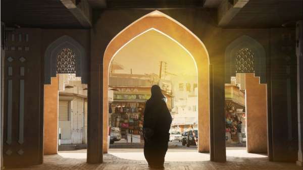 صورة ملف لسيدة عمانية تقف أمام سوق في مسقط