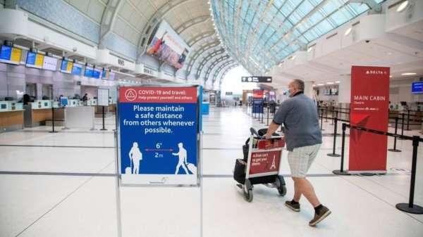 شخص يدفع ناقلة حقائب في مطار تورونتو
