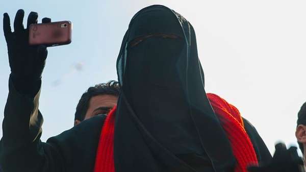 سيدة ترتدي النقاب تلتقط صورة بهاتفها المحمول في ميدان التحرير بالقاهرة خلال الانتفاضة الشعبية التي طالبت بالإطاحة بالرئيس السابق مبارك